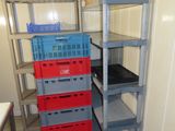 three shelves with crates stacked on them in a room