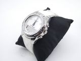 wrist watch sitting on a black pillow on a white surface