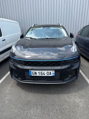 a black car parked in a parking lot next to a white van