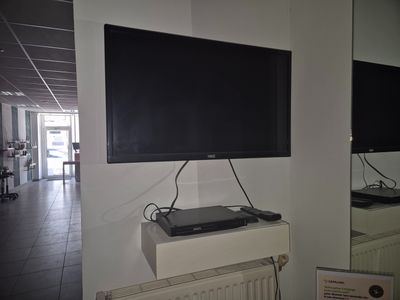 a flat screen tv mounted on the wall above a radiator