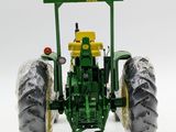 the toy tractor is green and has a yellow seat