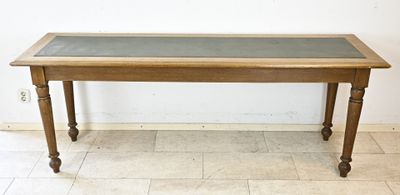 une table en bois avec un plateau en verre, posée sur un sol carrelé