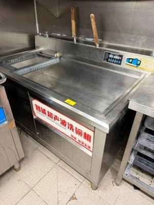 une grande cuisine professionnelle équipée d'un plan de travail en acier inoxydable