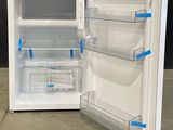 a white refrigerator with its door open on the floor