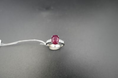Gros plan sur une bague ornée d'une pierre rouge