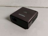 a close up of a small black device on a white surface