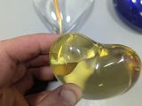 a person holding a glass heart shaped object in their hand