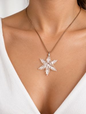 a close up of a woman wearing a white top and a necklace