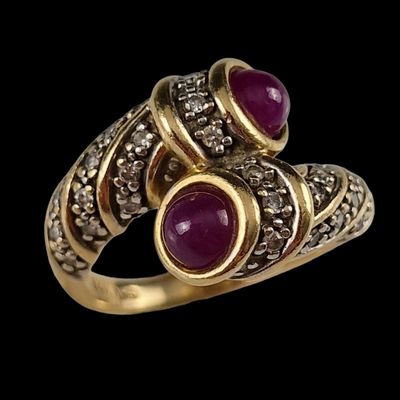 gros plan d'une bague en or avec deux rubis