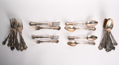 un grand nombre de cuillères et de fourchettes disposées sur une table