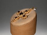 necklace with pearls and garnetts on display in a wooden box