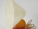 une tasse blanche avec un couvercle rouge posée sur un objet rouge