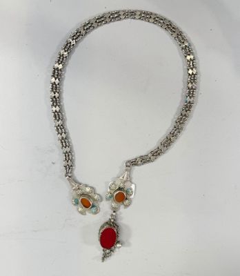 un gros plan d'un collier sur une surface blanche avec un fond blanc