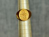 a gold ring that has a gold coin on it