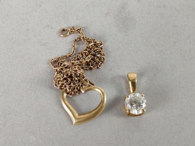 a gold necklace with a heart and a pendant with a diamond