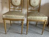 pair of gold painted chairs with floral upholstered seats