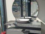 une salle de bains avec un lavabo et un miroir au mur