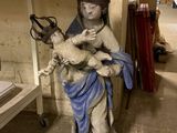 une statue représentant une femme tenant un bébé dans une pièce