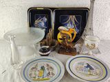 two plates and a bowl on a table with a glass vase