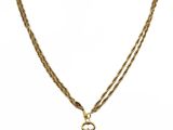 un collier en or avec un pendentif en pierre blanche monté sur une chaîne en or