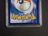 a pokemon card in a plastic case on a table