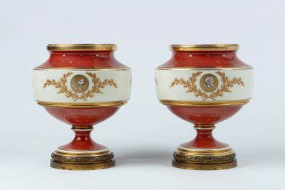 une paire de vases rouges et blancs ornés de motifs dorés