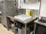 une cuisine équipée d'un évier, d'un réfrigérateur et d'autres objets posés sur le plan de travail