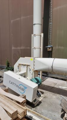 a machine that is sitting on the ground next to a pile of wood