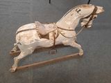 a wooden horse that is sitting on a stand