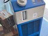 un climatiseur bleu et blanc posé sur une palette à côté de quelques cartons