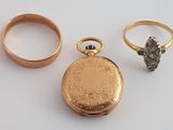 une montre de poche en or et une bague en diamant posées sur une table