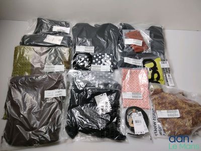de nombreux types de vêtements différents, rangés dans des sacs posés sur la table