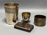 a silver cup and other silver items on a table