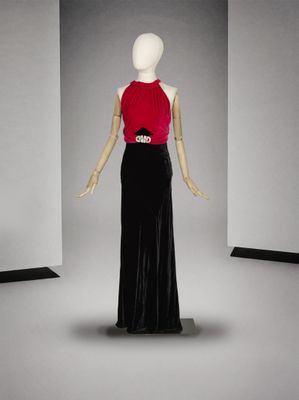 mannequin vêtu d'une robe rouge et noire dans une pièce blanche
