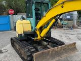 a picture of a yellow excavator parked in a parking lot