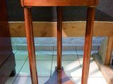 a small wooden table with a marble top on a tile floor