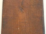 an old piece of wood with a tag on it sitting on a table