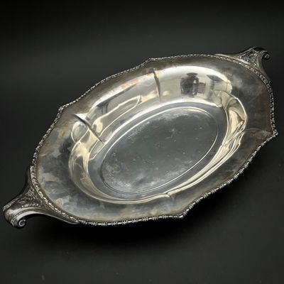 une assiette ancienne en argent sur fond noir, avec un fond noir