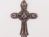 a silver cross with purple stones on a white background