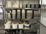 many plates and pans on a metal shelf in the kitchen