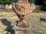 un grand vase posé au milieu d'une cour