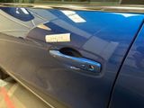 a blue car that has a sticker on the door handle