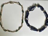 two necklaces that are sitting on a table