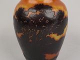 a black and orange vase sitting on a white surface