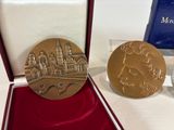 a gold medal with a picture of a castle on it