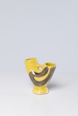 yellow and brown vase on a white table with a gray background