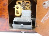 une horloge logée dans un meuble en bois