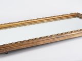 mirror on a stand with a gold frame and a white background