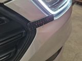 a close up of a car ' s headlight with a sticker on it