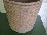 a wicker basket on a green table in front of a wallpaper